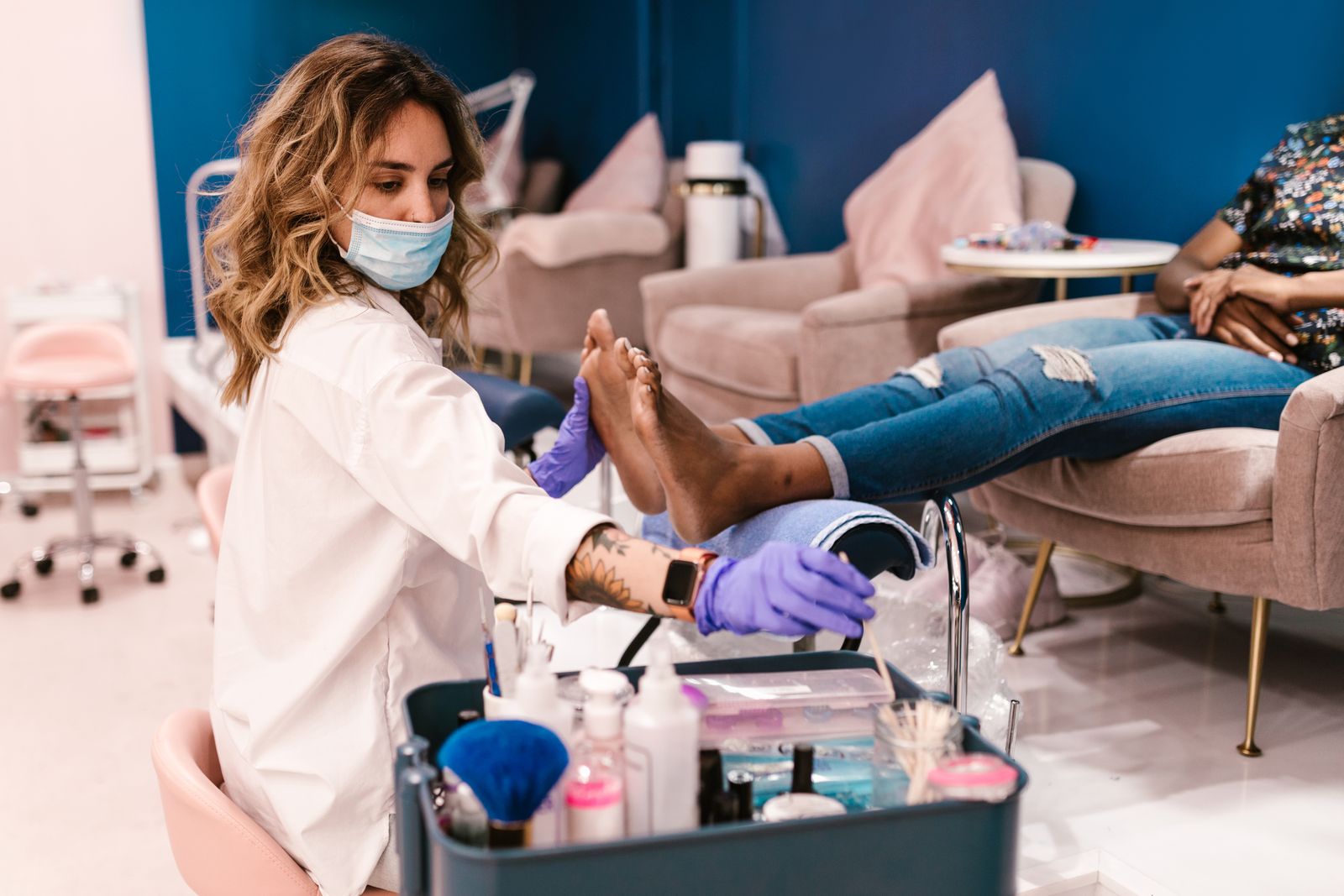 A beautician performs a pedicure on a client in a modern salon setting.